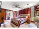 Cozy bedroom with red walls and a quilt, featuring natural light and comfortable furnishings at 17150 Se 168Th Ter, Weirsdale, FL 32195