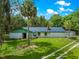 Exterior shot of the home, showcasing its architectural style, large yard, and established landscaping at 17150 Se 168Th Ter, Weirsdale, FL 32195