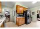 Functional kitchen with wood cabinets, black appliances, and an adjacent walk-in pantry for convenience at 17150 Se 168Th Ter, Weirsdale, FL 32195