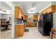 Bright kitchen with wooden cabinets, black appliances, and a view into the adjacent office space at 17150 Se 168Th Ter, Weirsdale, FL 32195