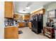 Functional kitchen with warm wood cabinets, black appliances, and a large window for natural light at 17150 Se 168Th Ter, Weirsdale, FL 32195