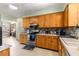Well-lit kitchen with wooden cabinetry, stainless steel appliances and mosaic backsplash at 17150 Se 168Th Ter, Weirsdale, FL 32195