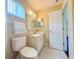 Bright bathroom featuring a toilet, vanity with sink, mirror and white door at 17574 Se 95Th Ct, Summerfield, FL 34491