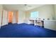 Spacious bedroom with blue carpet and large desk area at 17574 Se 95Th Ct, Summerfield, FL 34491