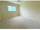 Bright bedroom features neutral carpet, ample natural light from the window and a ceiling fan at 17574 Se 95Th Ct, Summerfield, FL 34491