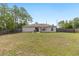 Spacious fenced backyard with a well-maintained lawn and mature trees, perfect for outdoor activities and relaxation at 2 Hemlock Trace Run, Ocala, FL 34472