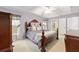 Bedroom with decorative wood bed frame, tray ceiling, and ensuite bathroom access at 2 Hemlock Trace Run, Ocala, FL 34472