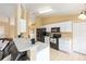 Well-lit kitchen boasts black appliances, white cabinets, and an adjacent living space at 2 Hemlock Trace Run, Ocala, FL 34472