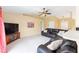 Spacious living room featuring vaulted ceilings, plush leather seating, and a ceiling fan at 2 Hemlock Trace Run, Ocala, FL 34472