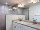 Modern bathroom with granite double sinks, updated fixtures, large mirror, and glass door to tiled walk-in shower at 22777 Sw Beach Blvd, Dunnellon, FL 34431