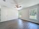 Bedroom features hardwood floors, neutral walls, a ceiling fan, and two windows with a peaceful outdoor view at 22777 Sw Beach Blvd, Dunnellon, FL 34431