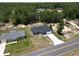 A quaint, new home with a gray roof and clean landscaping boasts a large driveway at 22777 Sw Beach Blvd, Dunnellon, FL 34431