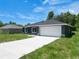 New home with a long driveway, spacious garage, and a neatly landscaped front yard at 22777 Sw Beach Blvd, Dunnellon, FL 34431
