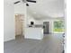 Open-concept interior showcasing sleek gray flooring, modern stainless appliances, and bright natural light at 22777 Sw Beach Blvd, Dunnellon, FL 34431