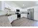 Bright kitchen featuring granite counters, stainless steel appliances, white cabinets and modern fixtures at 22777 Sw Beach Blvd, Dunnellon, FL 34431