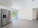 Bright kitchen features stainless steel fridge, white cabinets and hardwood floors and a sliding glass door with access to outdoors at 22777 Sw Beach Blvd, Dunnellon, FL 34431