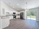 Bright kitchen featuring granite counters, stainless steel appliances, white cabinets and backyard access at 22777 Sw Beach Blvd, Dunnellon, FL 34431