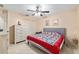 Cozy bedroom with a ceiling fan, dresser, closet and a comfortable bed with tile flooring at 2690 Sw 154Th Ln, Ocala, FL 34473