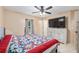 Bright bedroom featuring a ceiling fan, TV on a dresser, and a comfy bed with patterned quilt at 2690 Sw 154Th Ln, Ocala, FL 34473