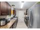 Well-lit kitchen with tile flooring, stainless steel fridge, and dark wood cabinets at 2690 Sw 154Th Ln, Ocala, FL 34473