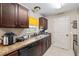 This kitchen has granite countertops, stainless steel sink, tile flooring, and dark cabinets at 2690 Sw 154Th Ln, Ocala, FL 34473