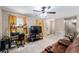 Living room showcasing tile floors, yellow curtains, a ceiling fan, and access to other rooms at 2690 Sw 154Th Ln, Ocala, FL 34473