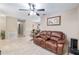 Spacious living room with tile floors, neutral-toned walls, a ceiling fan, and a comfortable leather sofa at 2690 Sw 154Th Ln, Ocala, FL 34473