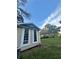 Side view of home with board and batten and large windows overlooking green lawn and mature trees at 3005 Ne 19Th Ave, Ocala, FL 34479