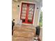 Charming home entrance features bright red double doors and a tiled porch with decorative plants at 3005 Ne 19Th Ave, Ocala, FL 34479