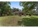 Large backyard featuring a pergola, lush lawn, and mature trees, ideal for outdoor activities and relaxation at 3880 Sw 6Th Ave, Ocala, FL 34471