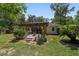 Inviting backyard patio area featuring a wooden pergola and lush landscaping, perfect for outdoor relaxation at 3880 Sw 6Th Ave, Ocala, FL 34471