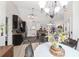 Open-concept kitchen featuring dark cabinets, granite counters, and a decorative chandelier over the adjacent dining area at 3880 Sw 6Th Ave, Ocala, FL 34471