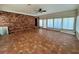Spacious living room with brick accent wall, tile floors, and lots of natural light at 4000 Sw 6Th Ave, Ocala, FL 34471