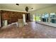 Spacious living room with brick wall, tiled floor, and bright windows offers potential for stunning design at 4000 Sw 6Th Ave, Ocala, FL 34471