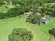 Sprawling green acreage featuring mature trees, equestrian buildings, and estate home at 402 Sw 127Th Pl, Ocala, FL 34473