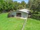 Aerial view of a green storage barn on green lawn with adjacent fencing at 402 Sw 127Th Pl, Ocala, FL 34473