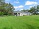 Expansive backyard featuring a well-maintained lawn, mature trees, and a charming screened patio at 402 Sw 127Th Pl, Ocala, FL 34473