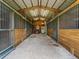 View of interior of wooden barn with multiple stalls, lighting and exterior door at 402 Sw 127Th Pl, Ocala, FL 34473