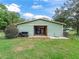 Exterior view of a green storage barn on a lush green lawn surrounded by trees at 402 Sw 127Th Pl, Ocala, FL 34473