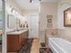 Bathroom with double sinks, soaking tub, and tiled shower with overhead lighting at 402 Sw 127Th Pl, Ocala, FL 34473