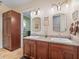 Bathroom with dual sinks, granite countertops, and custom cabinets for storage at 402 Sw 127Th Pl, Ocala, FL 34473