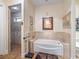 Elegant bathroom features a soaking tub, tiled shower with bench, and decorative lighting at 402 Sw 127Th Pl, Ocala, FL 34473