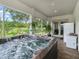 Enclosed patio featuring a hot tub and beautiful views of the backyard at 402 Sw 127Th Pl, Ocala, FL 34473
