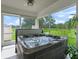 Enclosed patio featuring a hot tub and views of the beautiful backyard at 402 Sw 127Th Pl, Ocala, FL 34473
