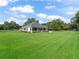 Expansive green lawn showcasing the house's exterior, with ample natural light and surrounding mature trees at 402 Sw 127Th Pl, Ocala, FL 34473