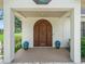 Close up of the front door with large wooden door and two blue pots at 402 Sw 127Th Pl, Ocala, FL 34473