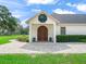 Close up of a home's front entrance featuring a large decorative wood door and stone pavers at 402 Sw 127Th Pl, Ocala, FL 34473