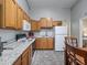Functional kitchen featuring wooden cabinets, granite countertops, and modern appliances for meal preparation at 402 Sw 127Th Pl, Ocala, FL 34473