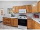 Well-lit kitchen area with granite countertops, stainless steel appliances, and wooden cabinetry at 402 Sw 127Th Pl, Ocala, FL 34473