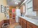 Laundry room with wooden cabinets, countertop, stainless steel sink, and a stacked washer and dryer at 402 Sw 127Th Pl, Ocala, FL 34473